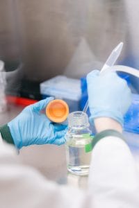 Scientist getting fluid out of a bottle