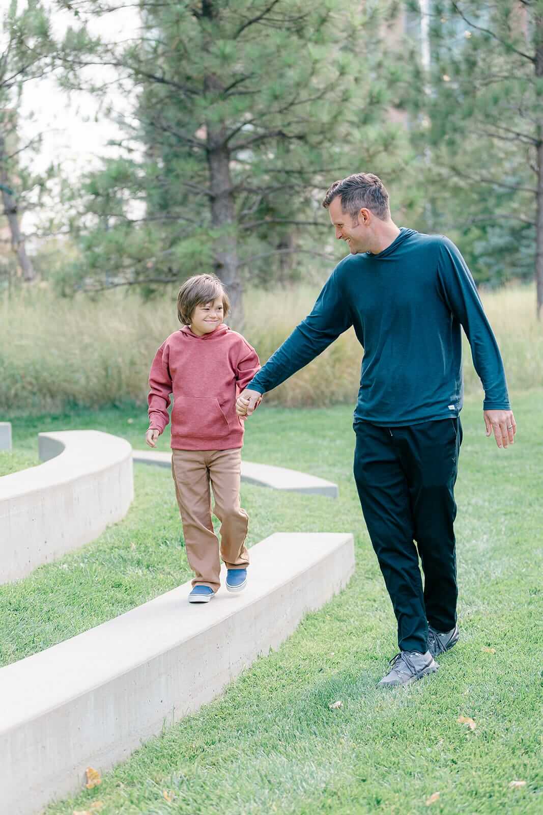 Young boy with Down syndrome walking with his dad