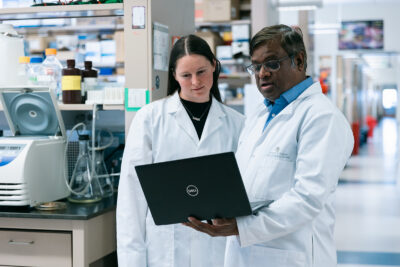 Two scientists ina. lab looking at data on a computer