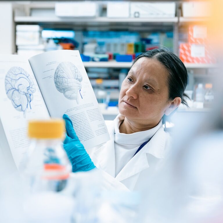 Scientist looking at a book in a lab